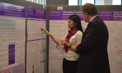 A researcher speaking to a man in a suit during the CE Showcase Day