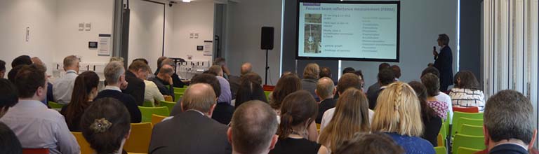 An audience looking at a presenter at a university event