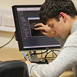 A male researcher analysing data on a computer