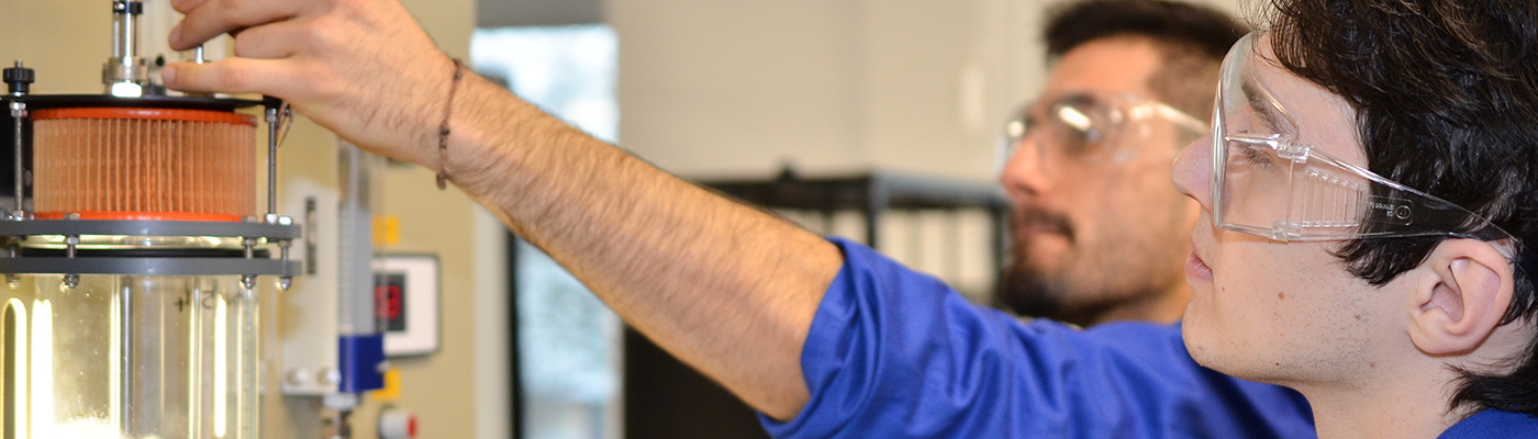 Two male researchers operating machinery with arms outstretched