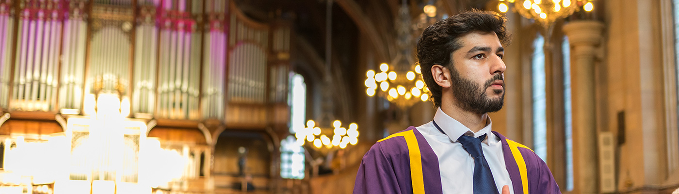 Male student in his graduation robes in Whitworth Hall