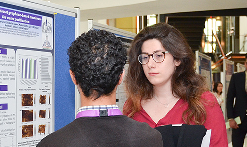 A man and woman in conversation at a postgraduate conference