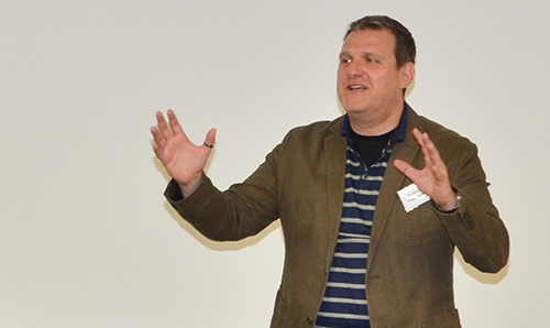 A researcher gesticulating as he gives a lecture