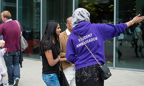 A student ambassador pointing the way during an open day