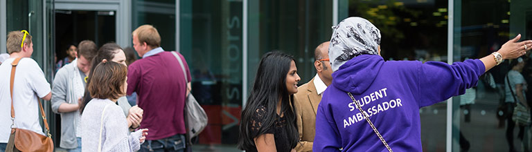 Prospective students in discussion with current student on campus on open day