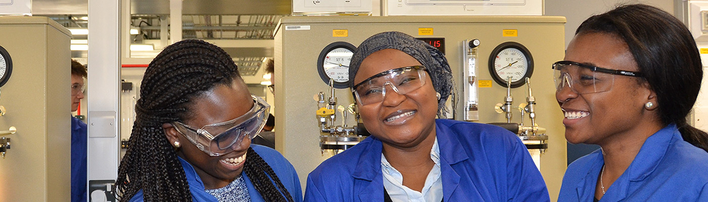 Three students sharing a joke in a laboratory